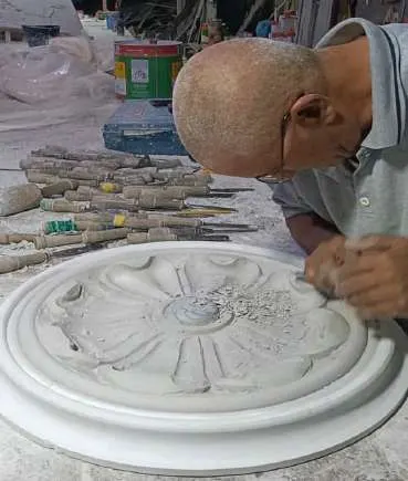 حرفي يشطّب زخرفة دائرية من GRC